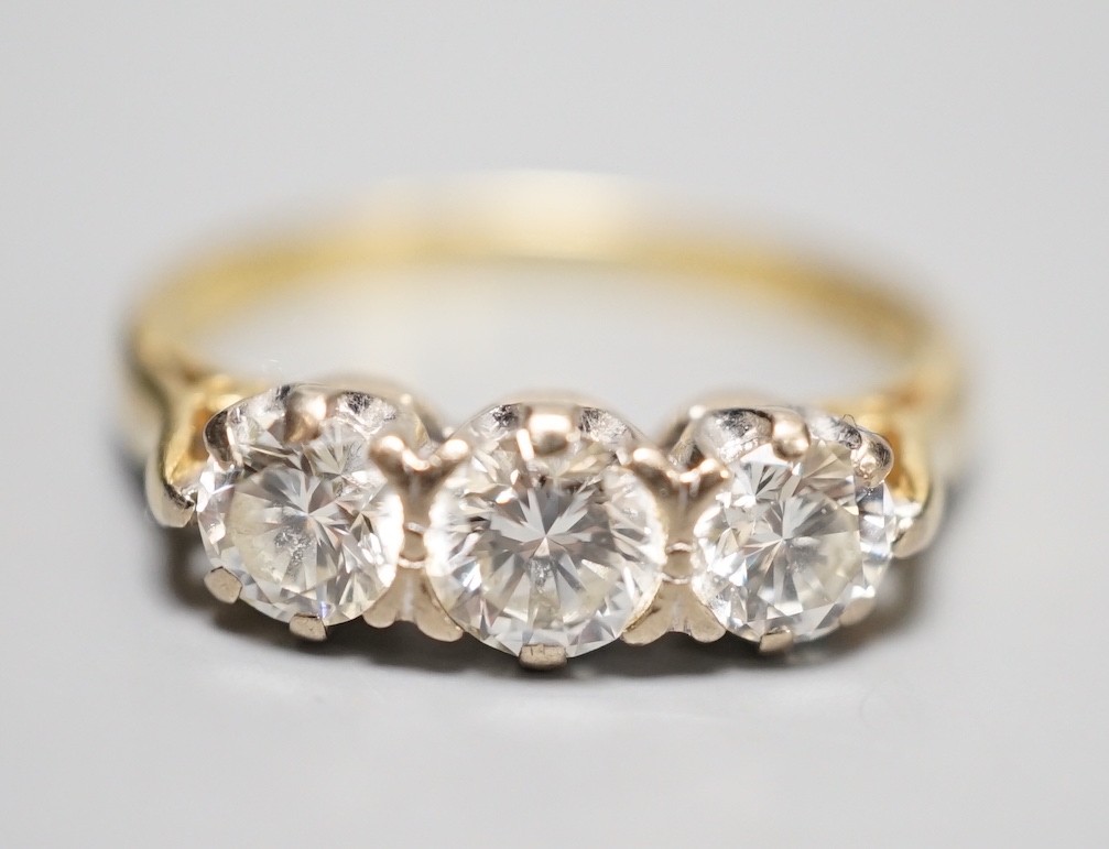 A modern 18ct gold and three stone diamond ring, size L, gross weight 3.3 grams